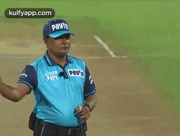 The Umpire is sweeping his hand in front of his chest.