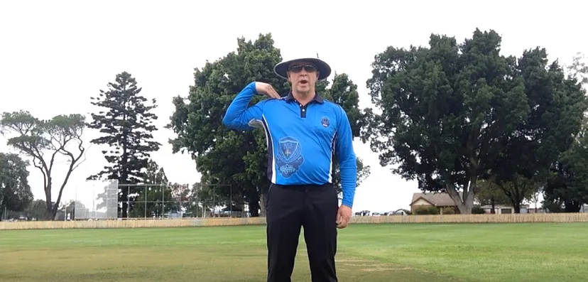 Umpire is extending the arm and tapping the shoulder